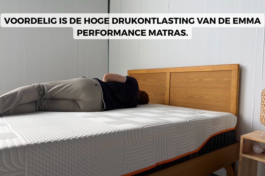 Een man ligt te slapen in bed op een Emma Performance-matras